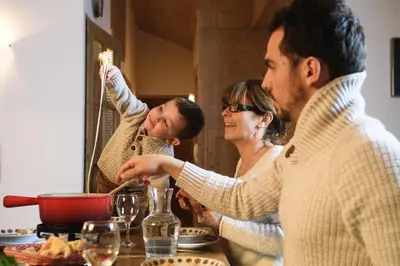 a group of people standing around a table eating food at CGH Résidence Boutique Le Hameau De Pierre Blanche in Les Houches