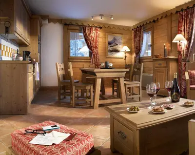 a kitchen and dining room with a table and chairs at CGH Résidence Boutique Le Hameau De Pierre Blanche in Les Houches