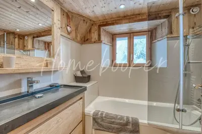 a bathroom with a shower and a bathtub at Chalet Hermine in Megève