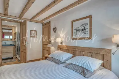 a bedroom with a bed with a wooden headboard at Chalet Hermine in Megève