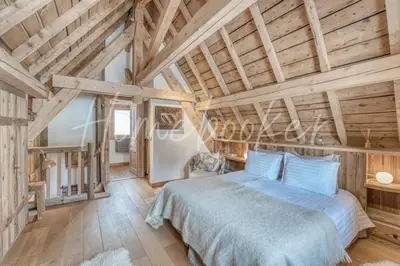 a bedroom with a bed and a wooden ceiling at Chalet Hermine in Megève