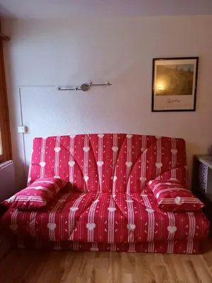a red couch sitting in a living room at Le Prarion 2 in Les Houches