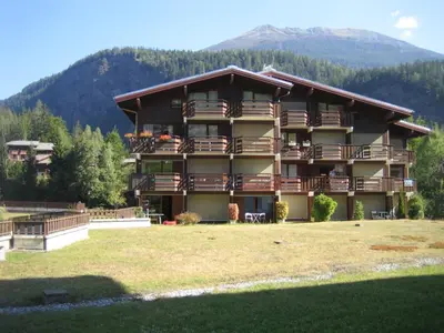 a large apartment building with balconies and a mountain at Le Prarion 2 in Les Houches