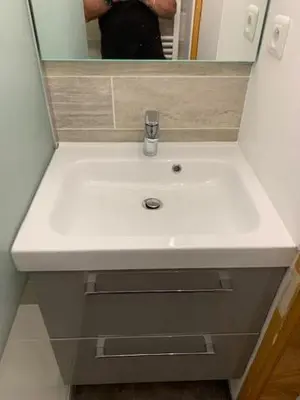a person taking a picture of a white bathroom sink at Le Prarion 2 in Les Houches