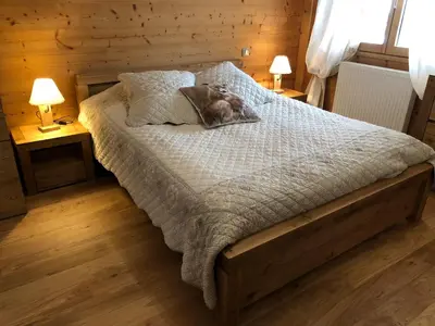 a bedroom with a bed with two lamps on two tables at Chalet Luxe Les Mélèzes in Samoëns