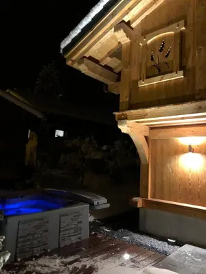 a hot tub in a backyard at night at Chalet Luxe Les Mélèzes in Samoëns