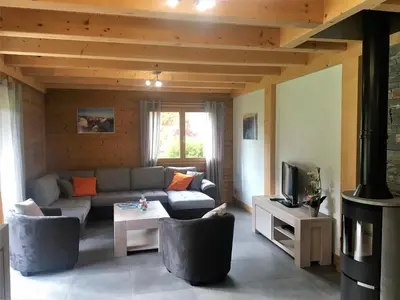 a living room with a couch and a tv at Chalet Luxe Les Mélèzes in Samoëns