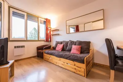 a living room with a couch and a mirror at Apartment Chamois Blanc 6 - Chamonix Haven with great views in Chamonix-Mont-Blanc