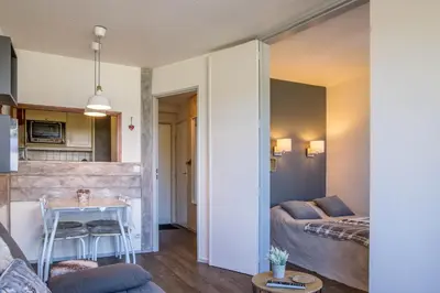 a living room with a bed and a table in a room at Au Pied Du Mont-Blanc - Chamonix in Chamonix-Mont-Blanc