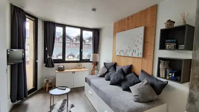 a living room with a couch and some windows at Au Pied Du Mont-Blanc - Chamonix in Chamonix-Mont-Blanc
