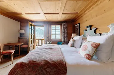 a bedroom with a large bed with a wooden ceiling at Les Chalets du Mont d'Arbois & Spa, Megève in Megève