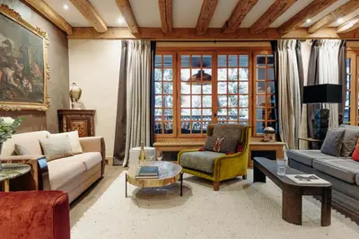 a living room with couches and a table at Les Chalets du Mont d'Arbois & Spa, Megève in Megève