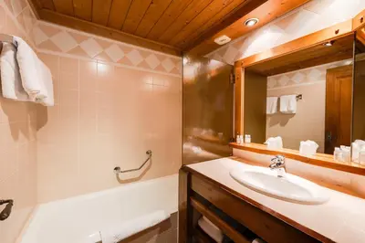 a bathroom with a sink and a bath tub at Hôtel La Grange d'Arly in Megève