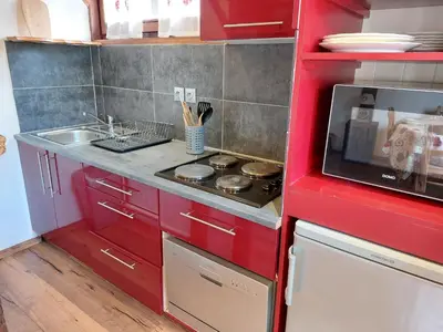 a kitchen with red cabinets and a sink and a stove at Studio Castel des roches by Interhome in Saint-Gervais-les-Bains