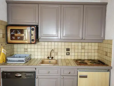 a kitchen with white cabinets and a sink and a microwave at Studio La pointe des Aravis 4 by Interhome in Saint-Gervais-les-Bains