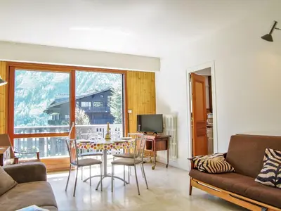 a living room with a couch and a table at Apartment Le Brévent-22 by Interhome in Chamonix-Mont-Blanc