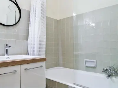 a bathroom with a tub and a sink and a shower at Apartment Le Brévent-22 by Interhome in Chamonix-Mont-Blanc