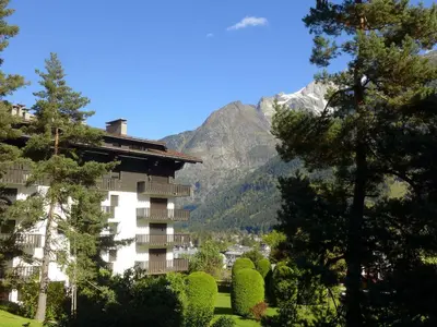 a building with trees in front of a mountain at Apartment Le Brévent-22 by Interhome in Chamonix-Mont-Blanc