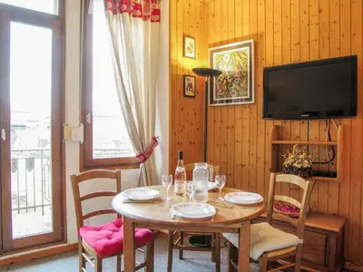 a dining room with a table with chairs and a television at Apartment Le Carlton-7 by Interhome in Chamonix-Mont-Blanc