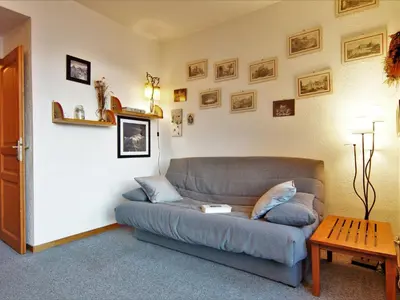 a living room with a blue couch and a table at Apartment Le Carlton-7 by Interhome in Chamonix-Mont-Blanc