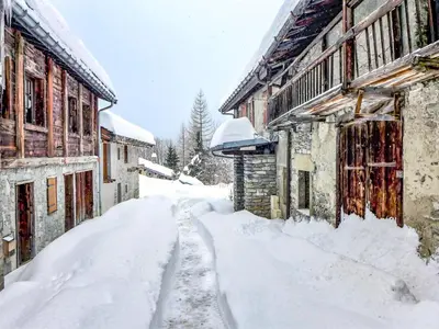 a snow covered alley between two wooden buildings at Apartment Chalet Le Tour by Interhome in Chamonix-Mont-Blanc