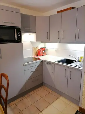 a kitchen with white cabinets and a sink and a microwave at cimes d'or in Les Contamines-Montjoie