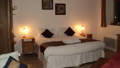 a bedroom with a large bed with two lamps at Ferme Dowena in Morillon