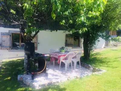 a table and chairs under a tree in a yard at Ferme Dowena in Morillon