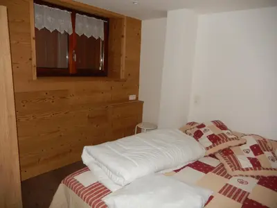 a small room with two beds and a window at Les Clarines in Saint-Gervais-les-Bains