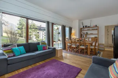 a living room with a couch and a dining room at Summit Apartment - Chamonix in Chamonix-Mont-Blanc