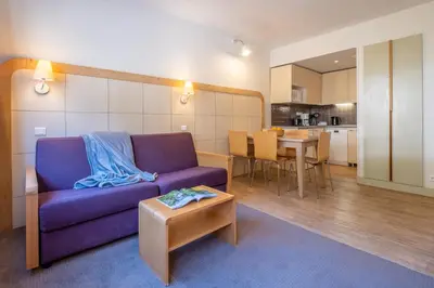 a living room with a table and a couch at Résidence Pierre & Vacances La Forêt in Flaine