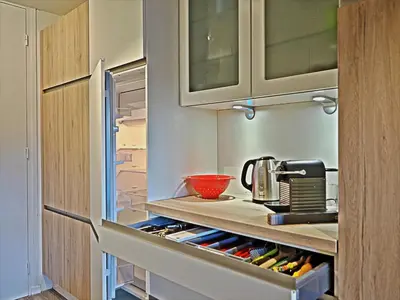 a kitchen with an open refrigerator filled with wine bottles at BelleVue centre, wifi, mountain view in Les Carroz d'Araches