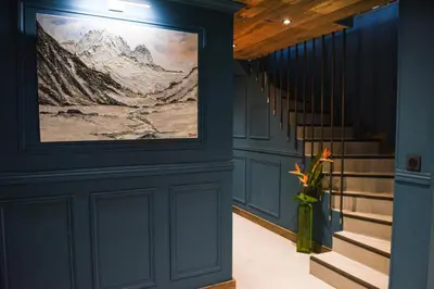 a painting on a wall in a hallway with stairs at Chalets Grands Montets in Chamonix-Mont-Blanc