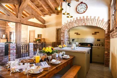 a kitchen with a wooden table and a clock on the wall at Chalets Grands Montets in Chamonix-Mont-Blanc