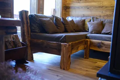a wooden couch sitting in a living room at Chalets Grands Montets in Chamonix-Mont-Blanc