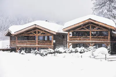 a couple of wooden buildings covered in snow at Chalets Grands Montets in Chamonix-Mont-Blanc