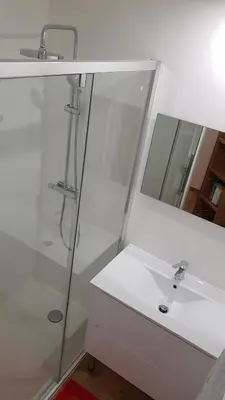 a white bathroom with a sink and a mirror at Les Carroz d'Araches in Les Carroz d'Araches