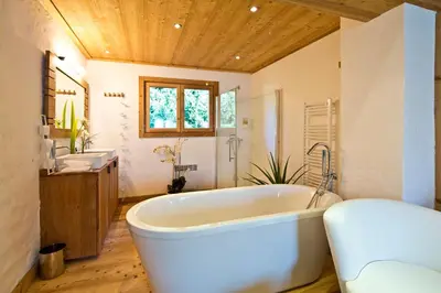 a large bathroom with a tub and two sinks at Chalet la Brunette in Megève