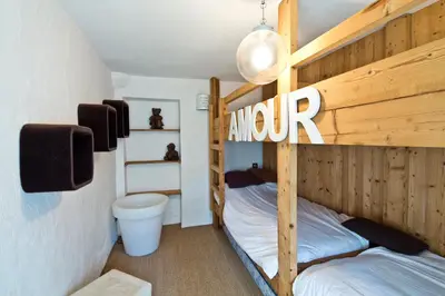 a bedroom with two bunk beds and a toilet at Chalet la Brunette in Megève
