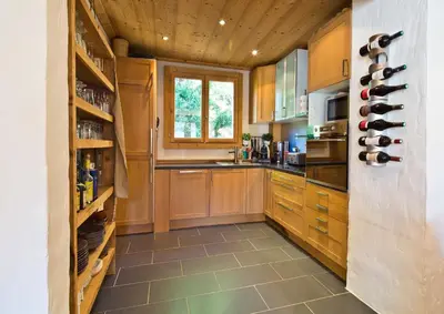 a large kitchen with wooden cabinets and a window at Chalet la Brunette in Megève