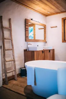 a bathroom with a tub and a sink and a ladder at Chalet la Brunette in Megève