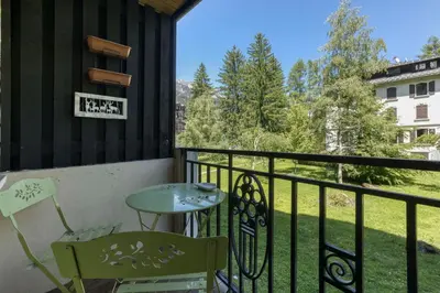 a balcony with a table and chairs and a view at Apartment Chamois Blanc 1 - Central Chamonix Haven in Chamonix-Mont-Blanc