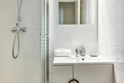 a white bathroom with a sink and a shower at Apartment Chamois Blanc 1 - Central Chamonix Haven in Chamonix-Mont-Blanc