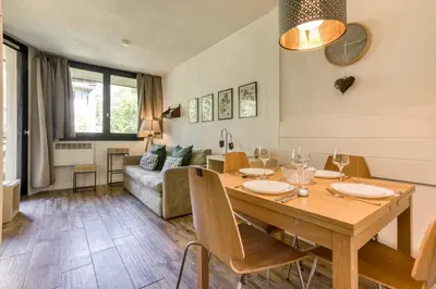 a dining room and living room with a wooden table at Apartment Chamois Blanc 1 - Central Chamonix Haven in Chamonix-Mont-Blanc