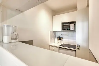a white kitchen with a counter and a microwave at Apartment Chamois Blanc 1 - Central Chamonix Haven in Chamonix-Mont-Blanc