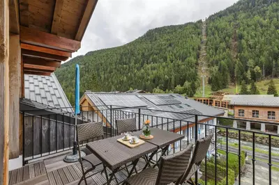 a balcony with a table and chairs and a mountain at Vallorcine Mont Blanc Spa in Vallorcine