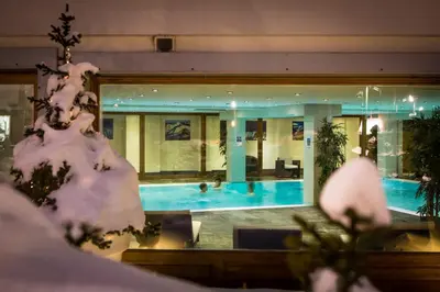 a house with a swimming pool with snow covered trees at Vallorcine Mont Blanc Spa in Vallorcine