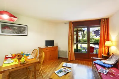 a living room with a table and a couch at Résidence Goélia Le Nevez in Les Contamines-Montjoie