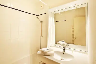 a white bathroom with a sink and a mirror at Résidence Goélia Le Nevez in Les Contamines-Montjoie