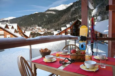 a table with food and drinks on a balcony at Résidence Goélia Le Nevez in Les Contamines-Montjoie